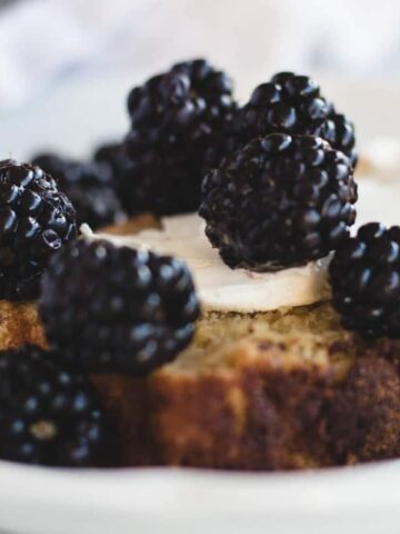 breakfast bread topped with cream cheese and blackberries.