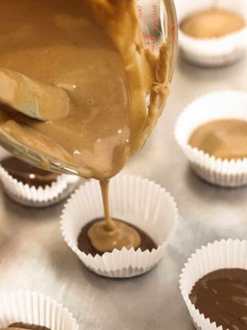 pouring peanut butter into mini cups.