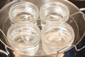empty mason jars in a pot of water