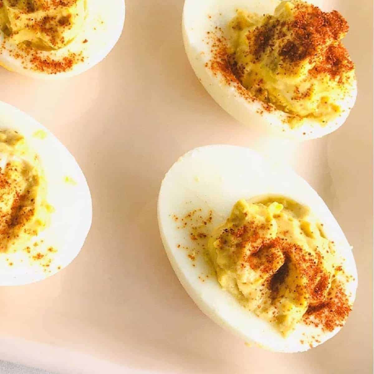 southern style deviled eggs on pink plate.