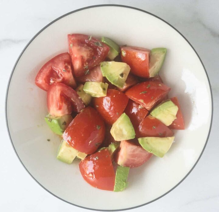 Avocado and tomatoes cut up in bowl.