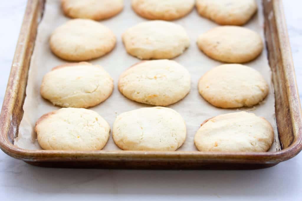 orange sugar cookies on baking sheet