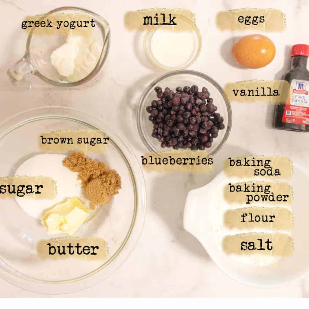 ingredients to make blueberry muffins sitting on table.