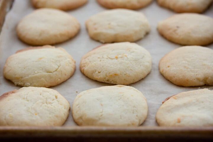 close u or orange sugar cookies on parchment lined baking sheet.