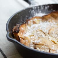 vlose upof applepancake in cast-iron skillet.