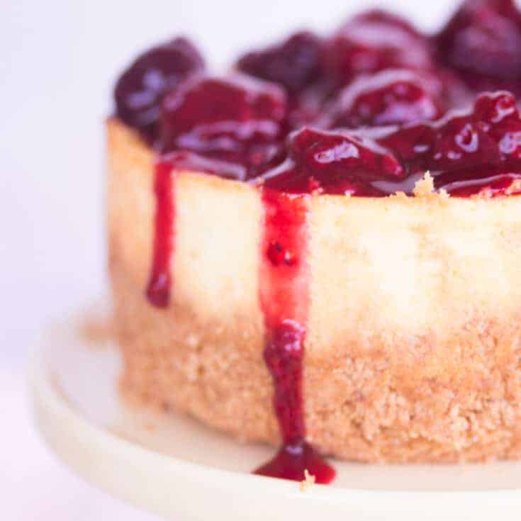 closeup of cheesecake topped with homemade blackberry sauce.