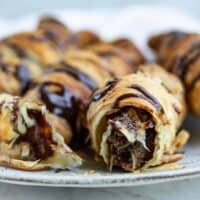close up of puff pastry chocolate croissants on plate.