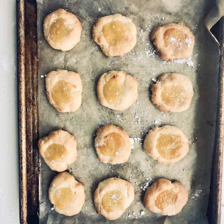 lemon curd cookies on parchment lined baking sheet.