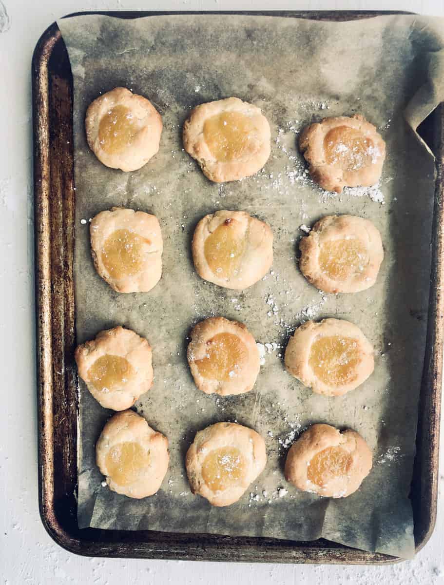 lemon curd cookies on parchment lined baking sheet.