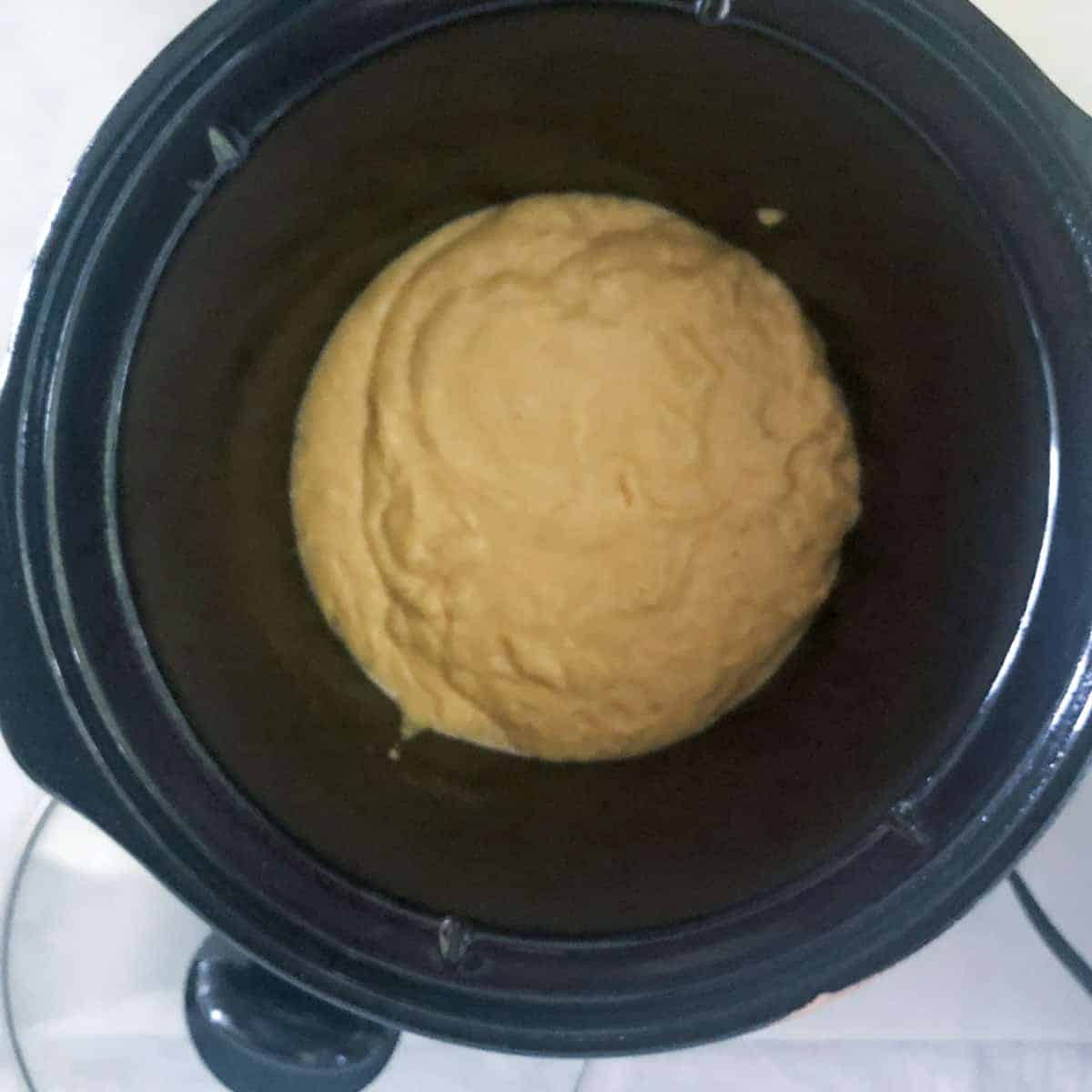 slowcooker cornbread batter in bottomof 3 quart slow cooker.