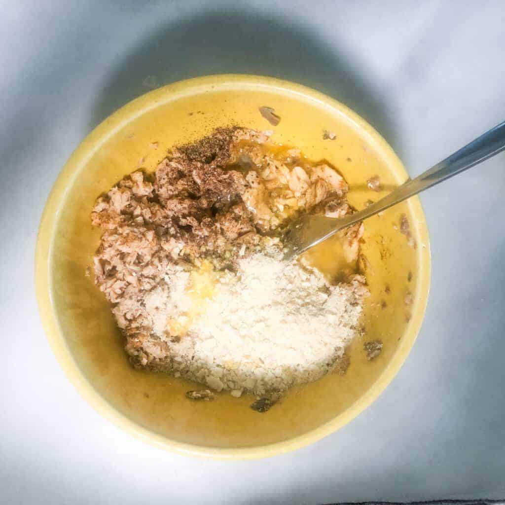 canned salmon, saltine, seasoning and egg in yellow bowl.