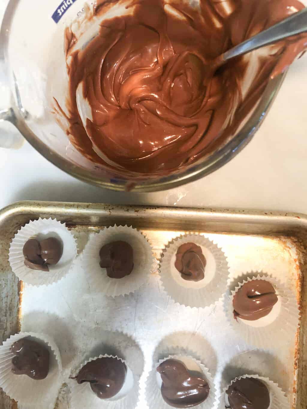 melted chocolate in measuring cup next to baking pan.