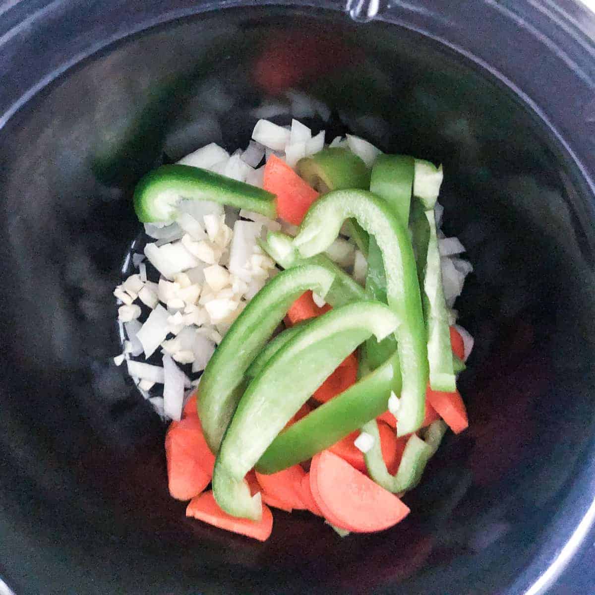 sliced onions, carrots, green pepper, and garlic in 3 quart slow cooker.