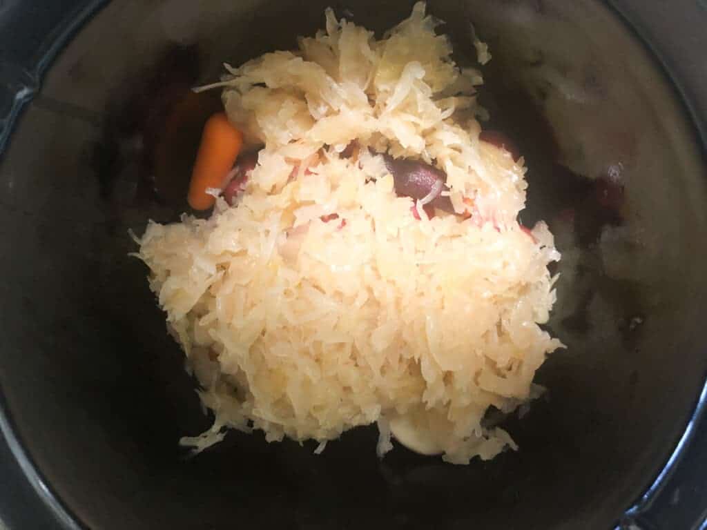 sauerkraut ove carrots and potatoes in 3-quart slow cooker.