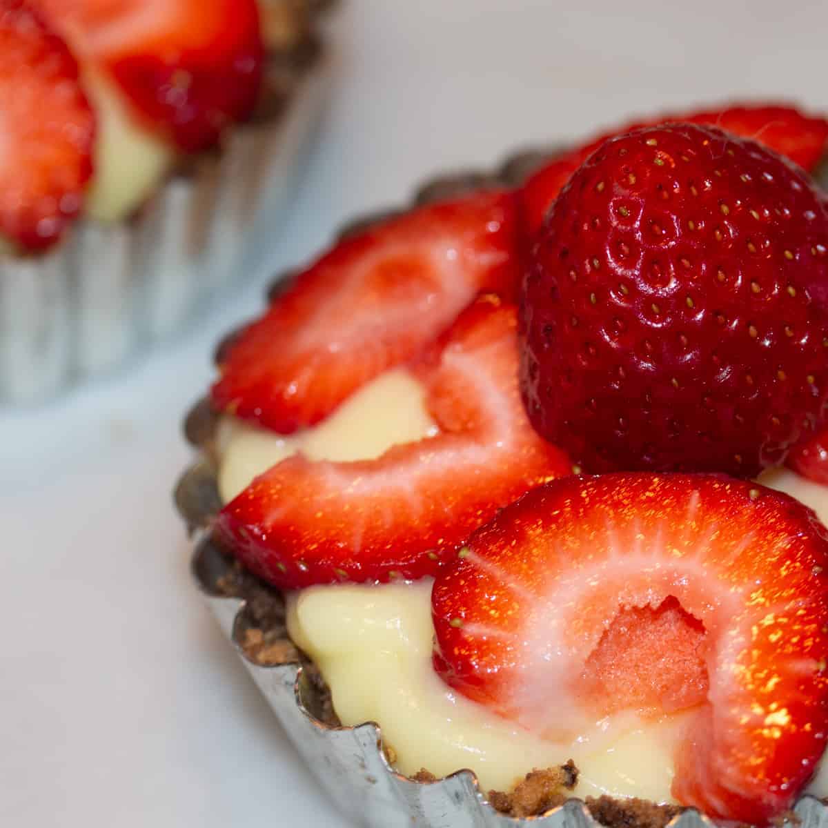 Small custard tart topped with strawberries.