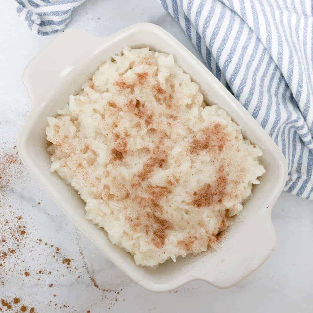 small baking dish of slow cooker rice pudding sprinkled with cinnamon sugar.