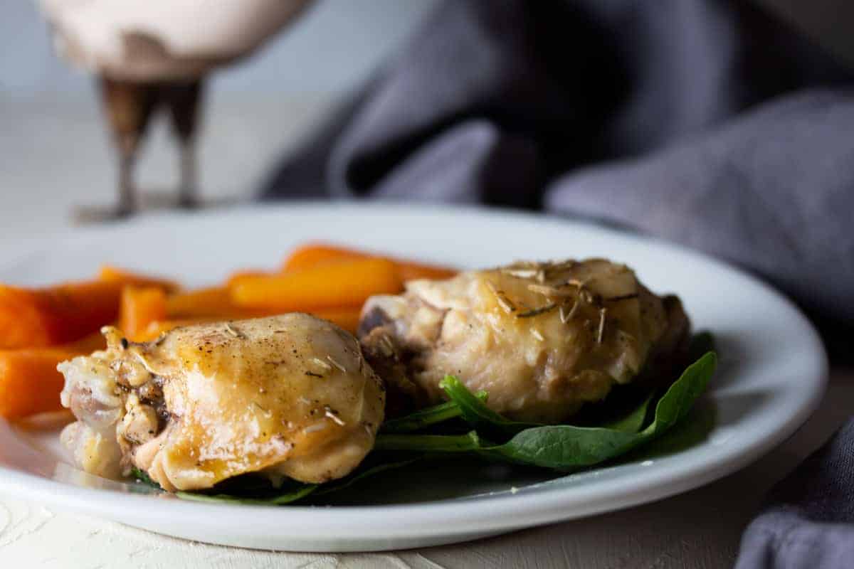 tuscan chicken thighs and carrots on bed of spinach.