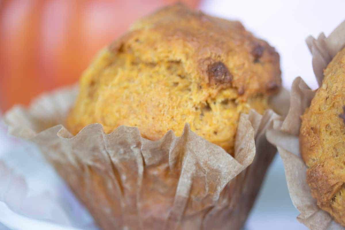 pumpkin muffin in partially peeled open paper liner.