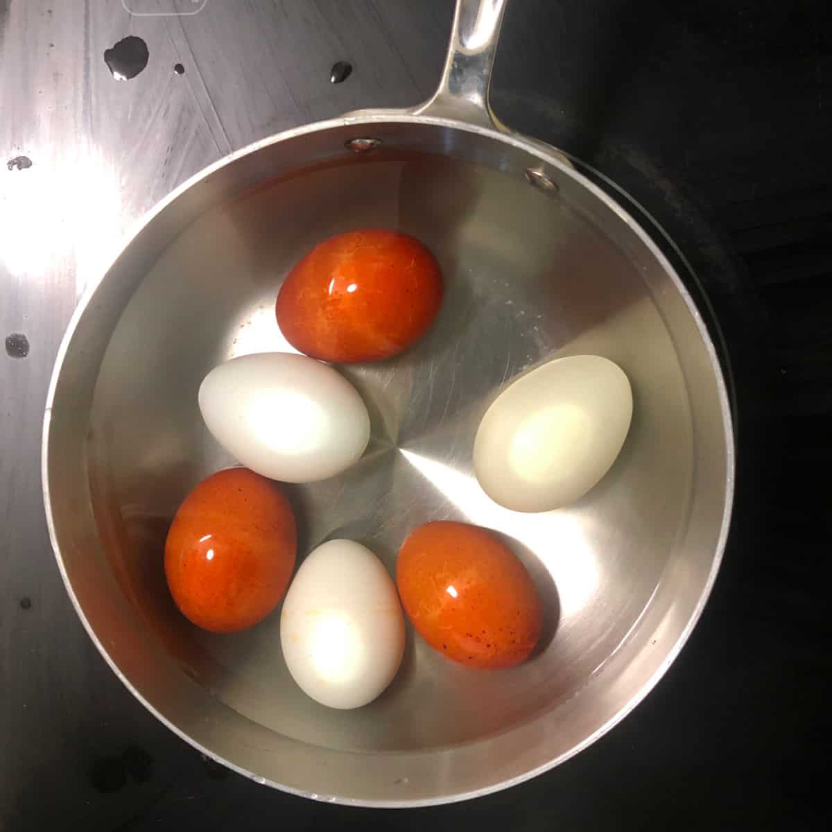 Eggs boijing in small saucepan.