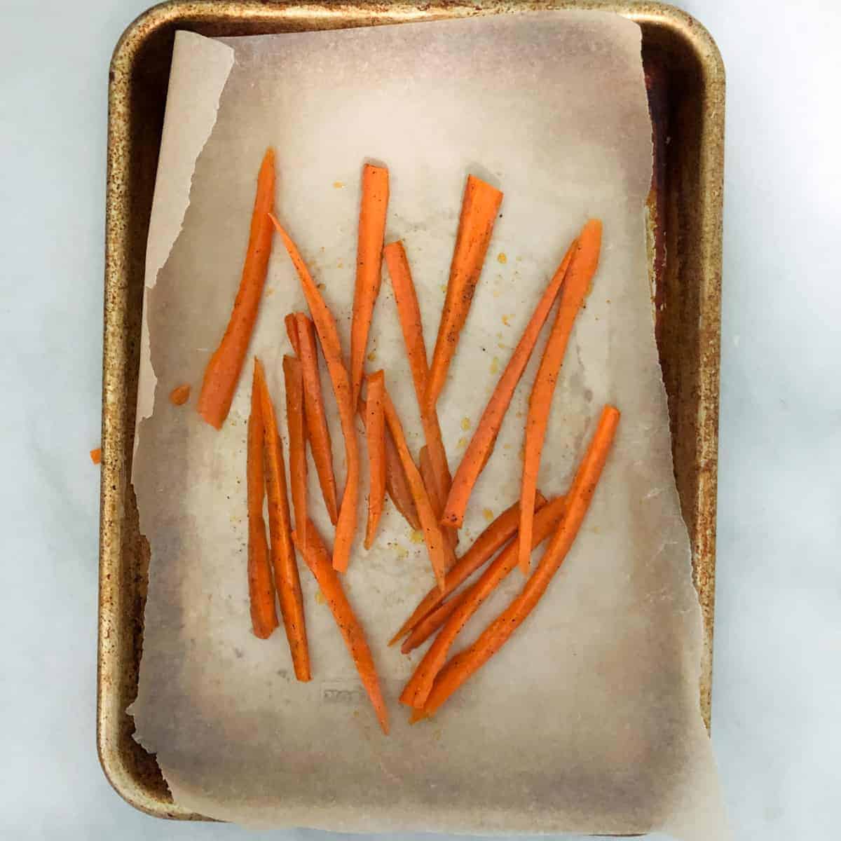 Sliced carrots on baking sheet.