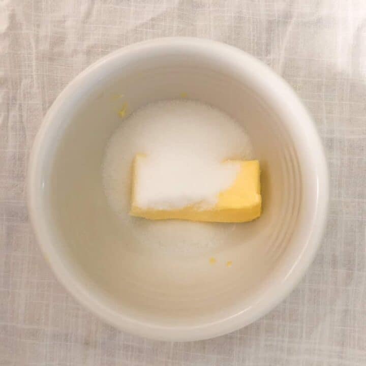 Softened butter and sugar in white bowl.