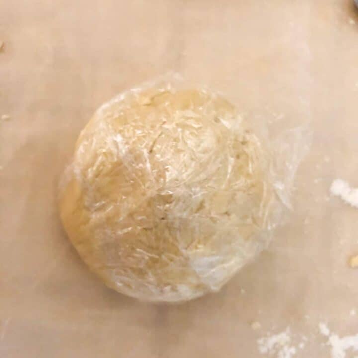 Ball of chilled shortbread cookie dough wrapped in plastic wrap.