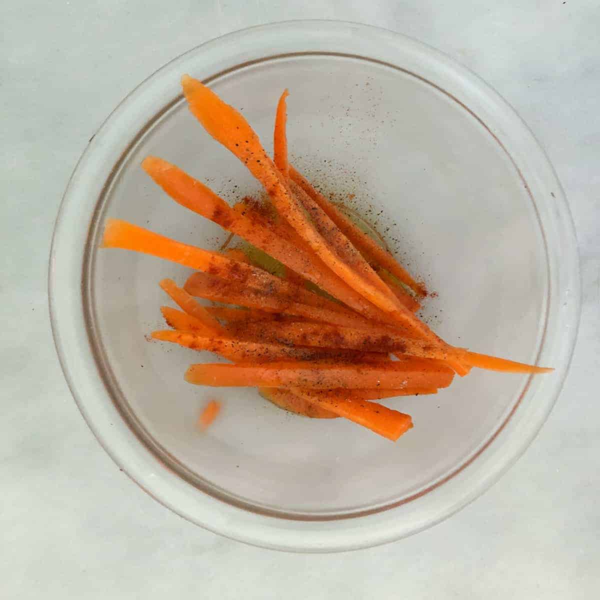 Raw sliced carrots in bowl.