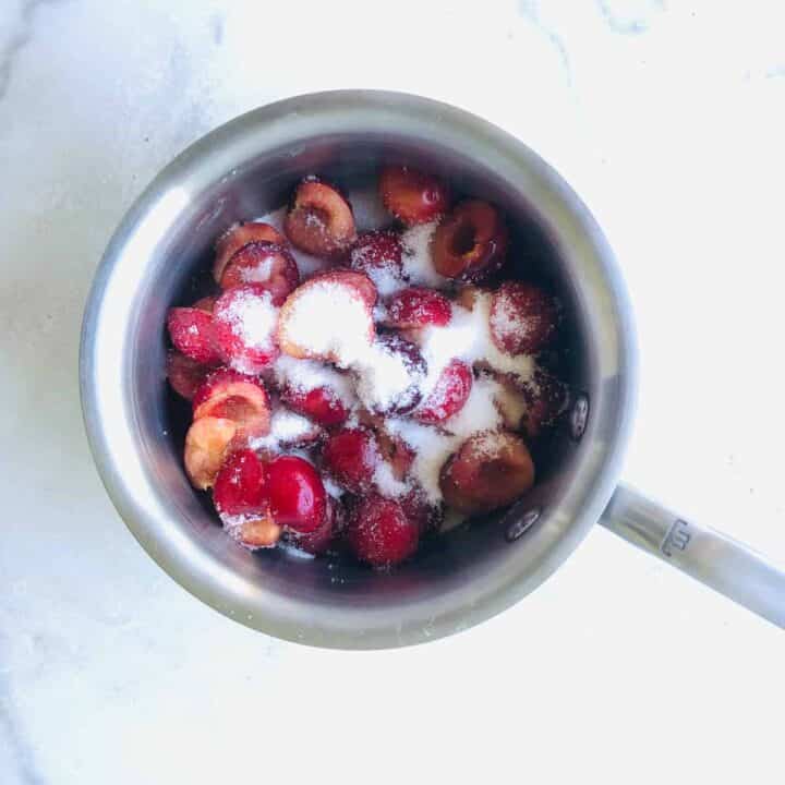 fresh cherries sliced with sugar in a small saucepan/