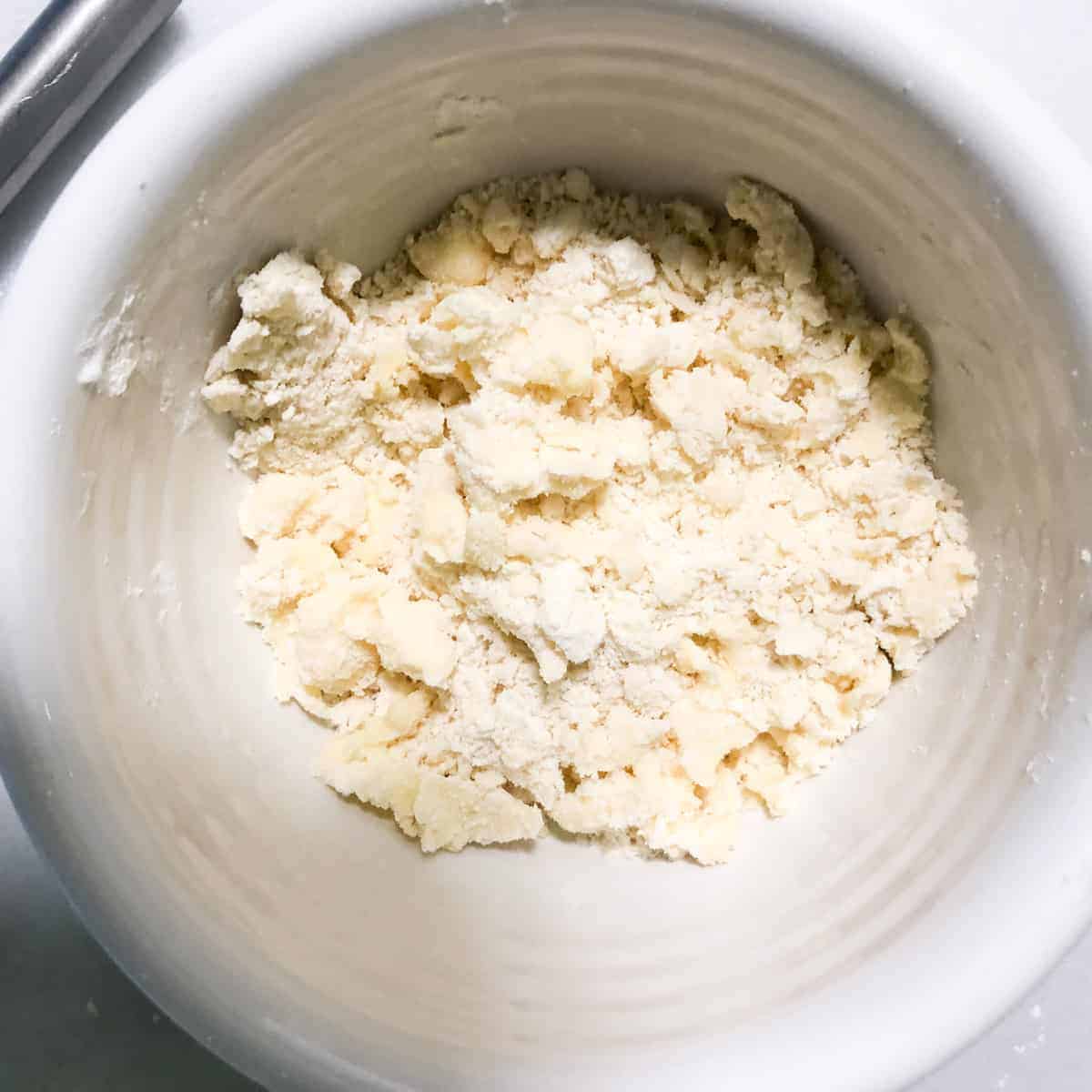 flour and butter crumbled in white bowl.