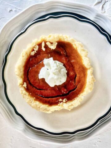 Homemade mini pumpkin pie topped with whipped cream.