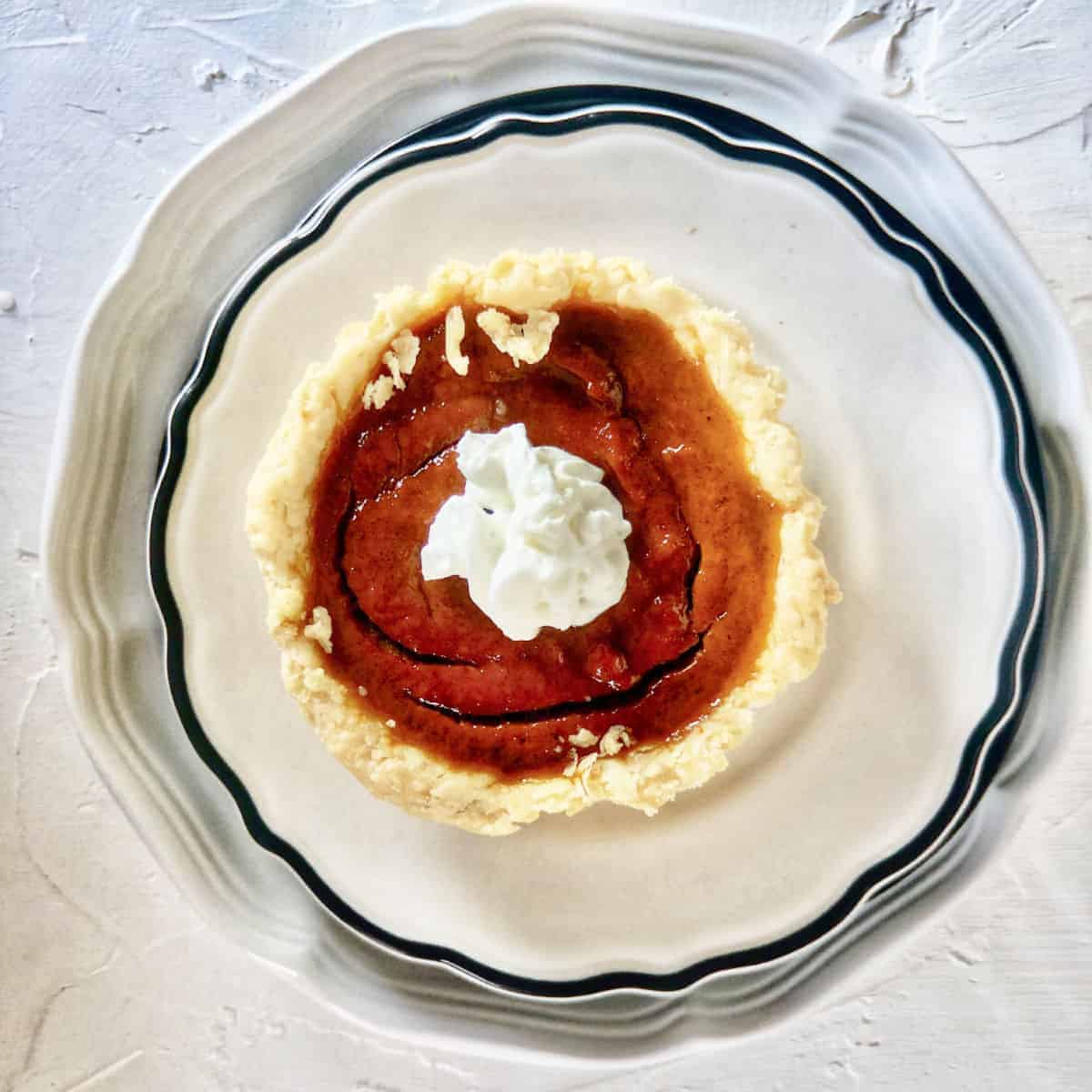 Homemade mini pumpkin pie topped with whipped cream.