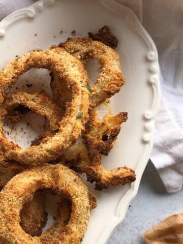 Baked onion rings on oval serving dish.