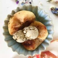 Baked apple and ice cream in blue bowl.