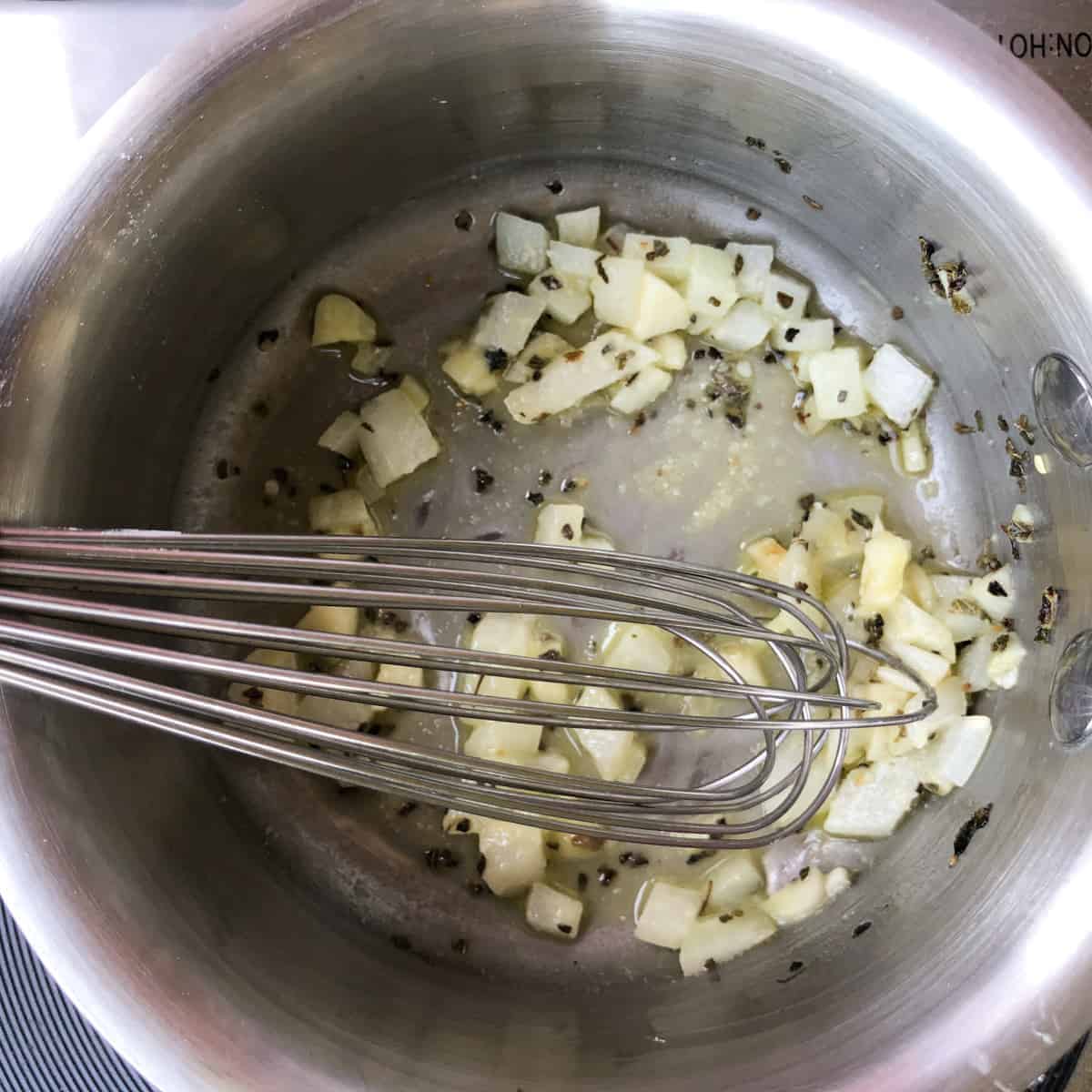 Butter, onion, garlic and oregano melting in saucepan.