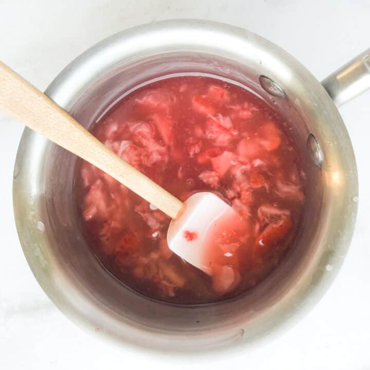 Strawberry glaze cooking in small saucepan.