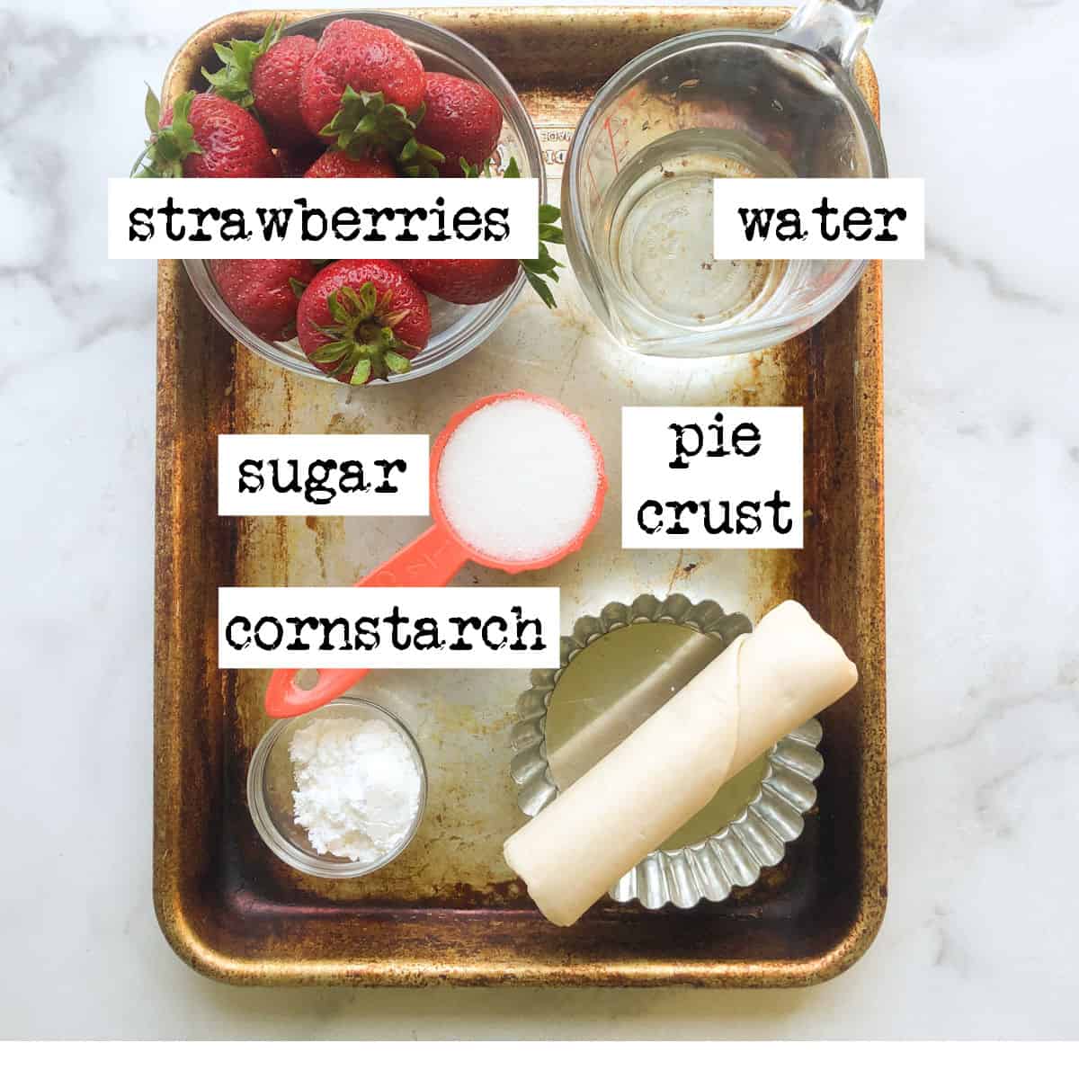 Strawberries, water, sugar,cornstarch, and pie crust on baking sheet.
