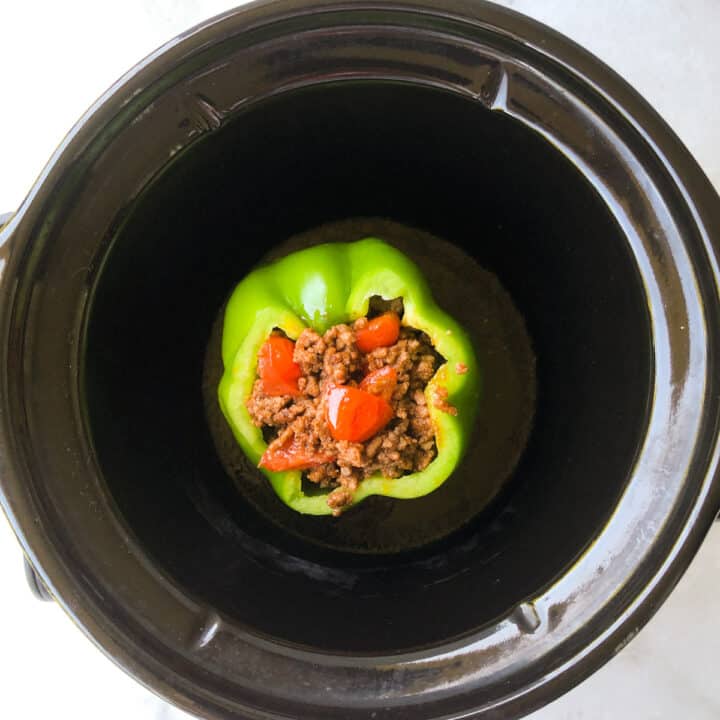 Green pepper stuffed with ground beef in a 2-quart slow cooker.