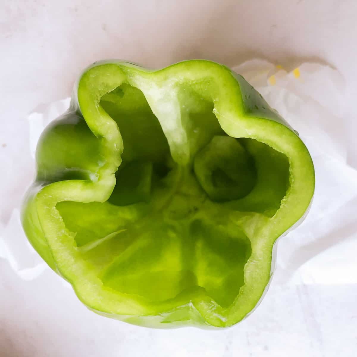 Fresh green pepper with top cut off and seeds removed.