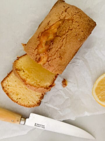 mini pound cake on table with knife and lemon slices.
