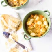Creamy vegetable soup in green bowl.