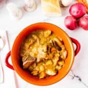 Short rib stew in orange bowl on table