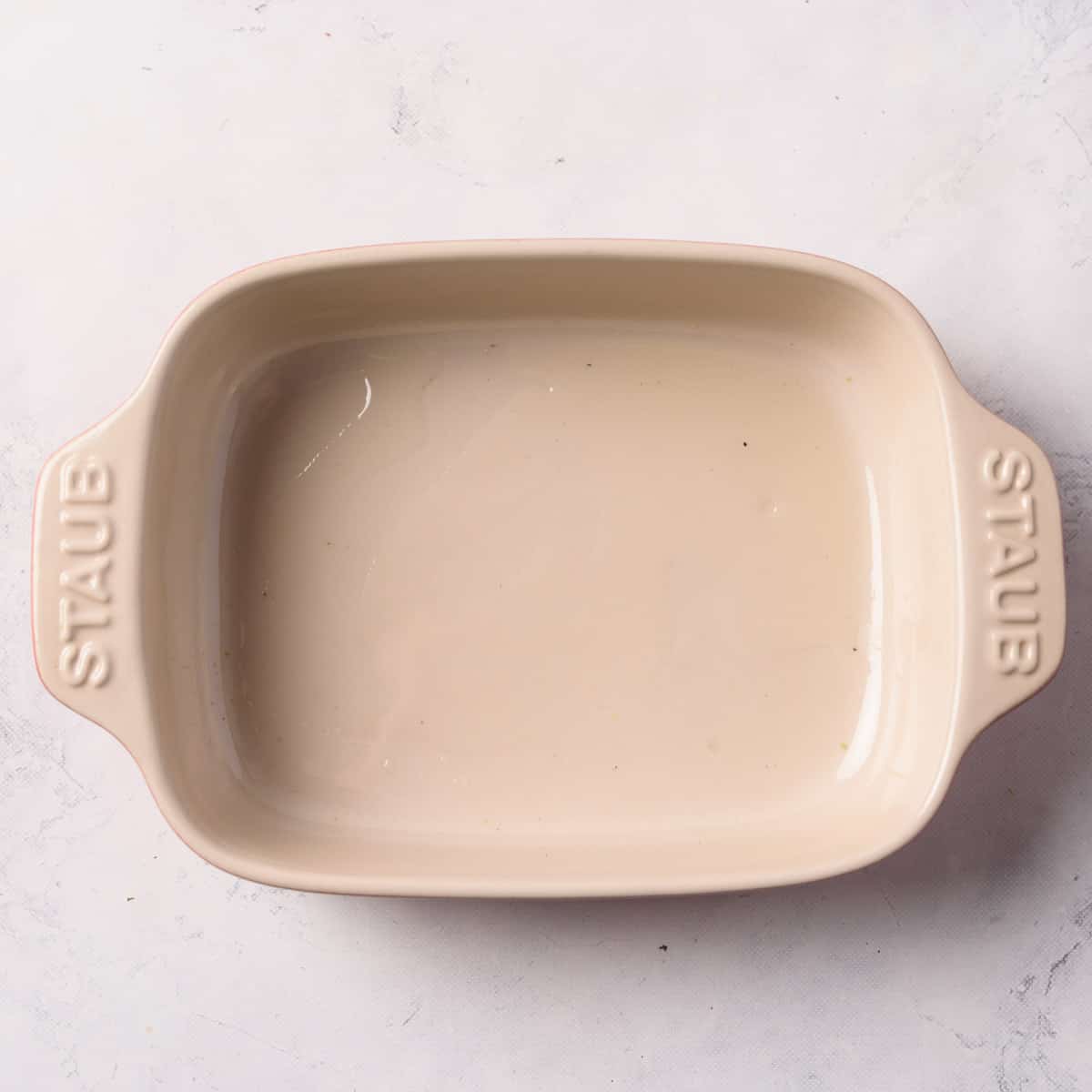 Small Staub baking dish coated with oil.
