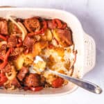 Potatoesd and sausage casserole inbaking dish with serving spoon.