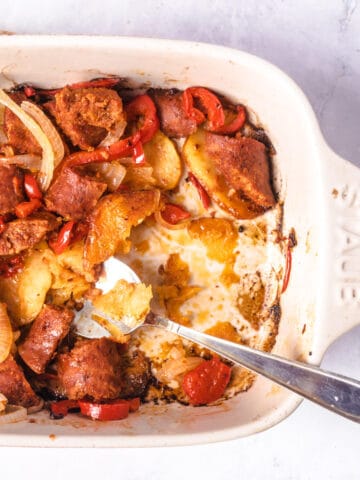 Potatoesd and sausage casserole inbaking dish with serving spoon.