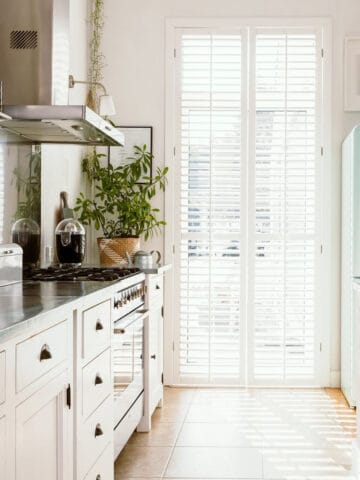Small galley kitchen with grey countertops and white cabinets.