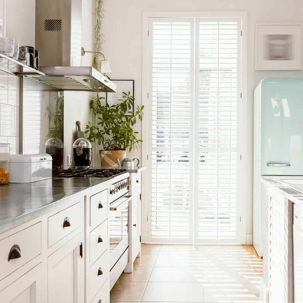 Small galley kitchen with grey countertops and white cabinets.