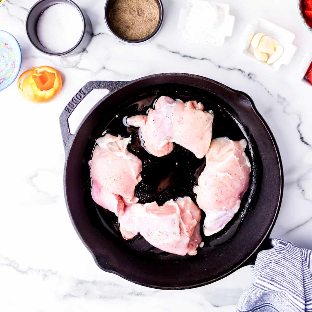 Skinless chicken cooking in skillet.