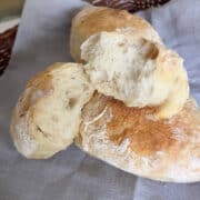 Three Ciabatta rolls on grey napkin.