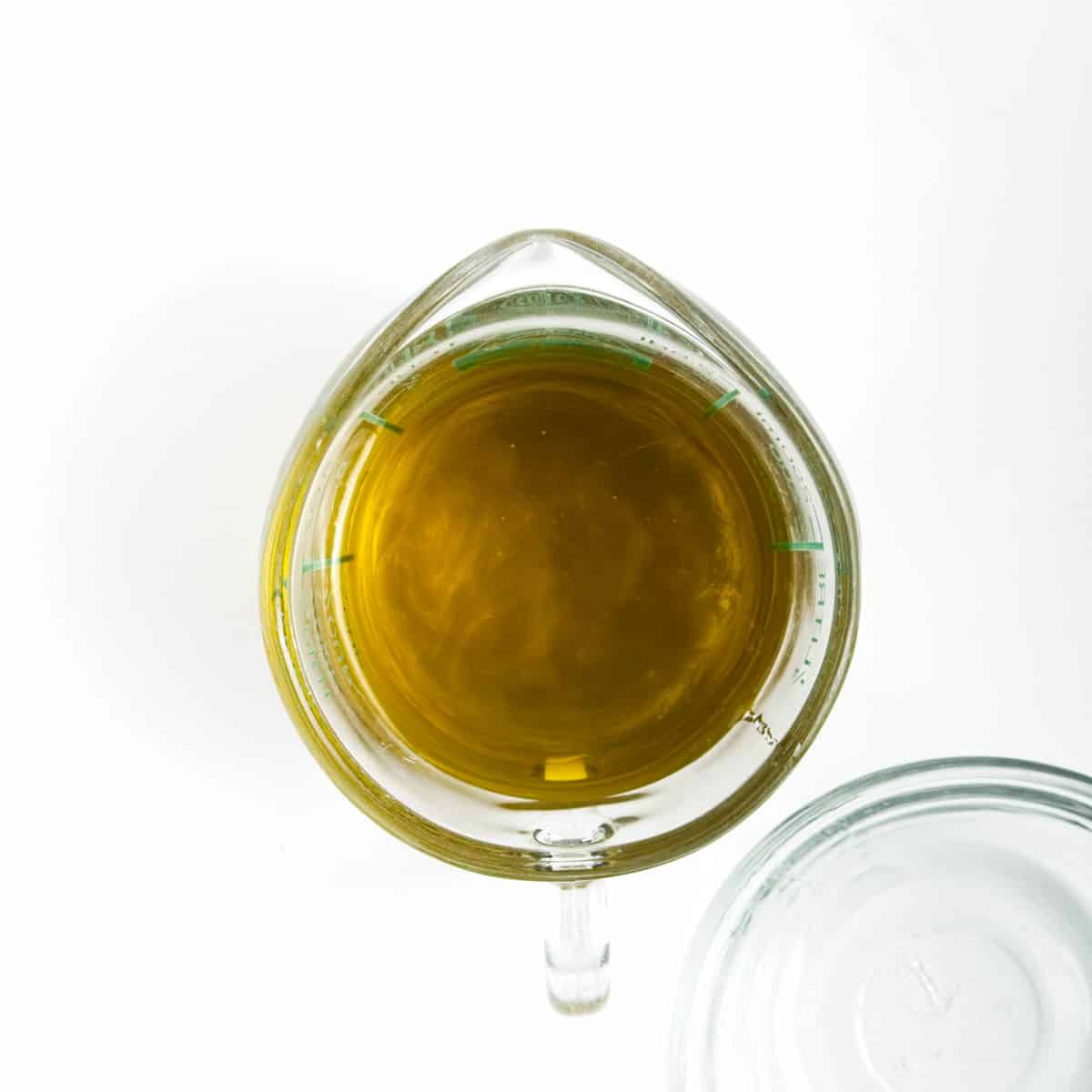 Olive oil and vegetable oil mixed together in a measuring cup.