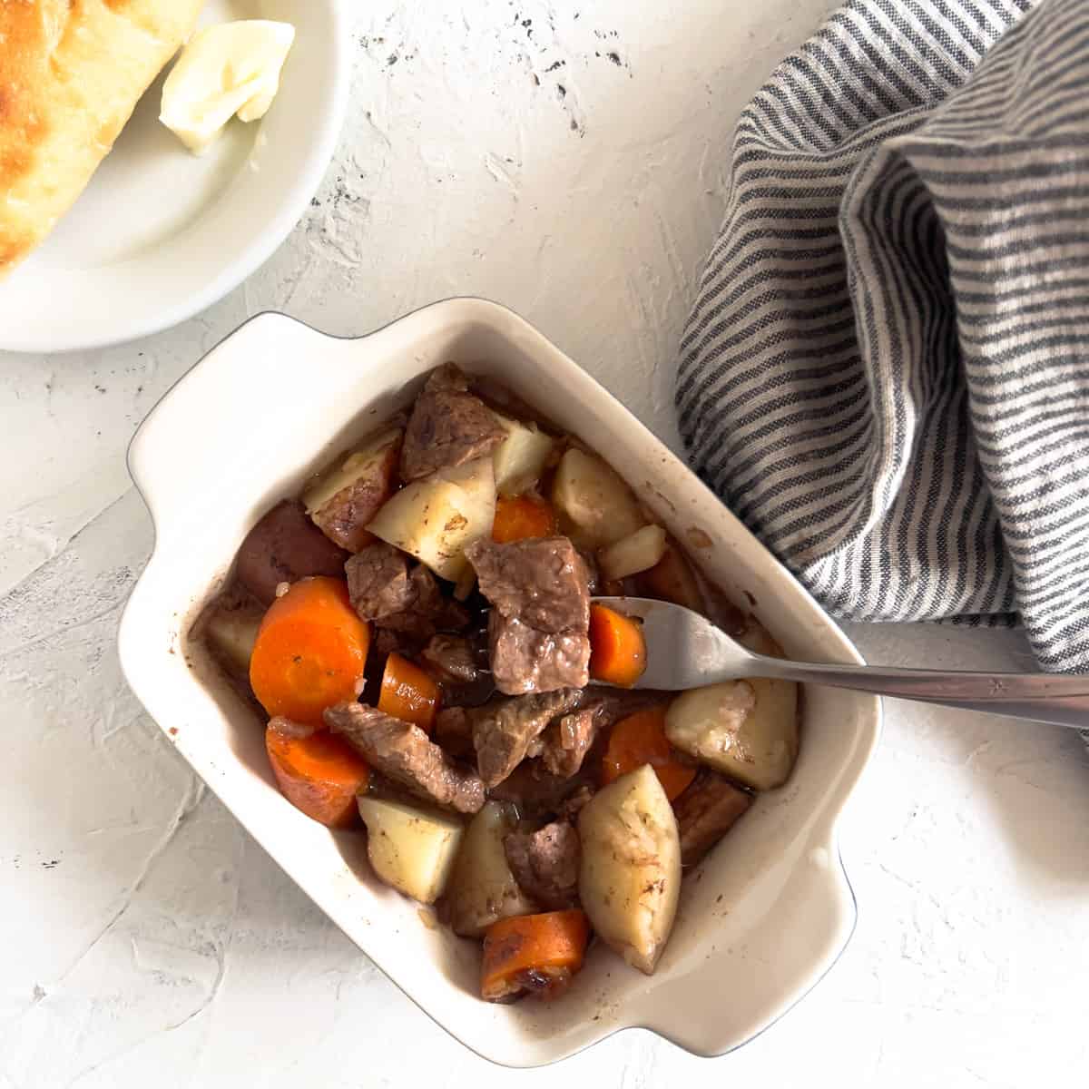 Single serving of baked beef stew in casserole dish.